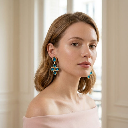 Model wearing the Byzance Cross Earrings, gold-tone brass, blue cabochons