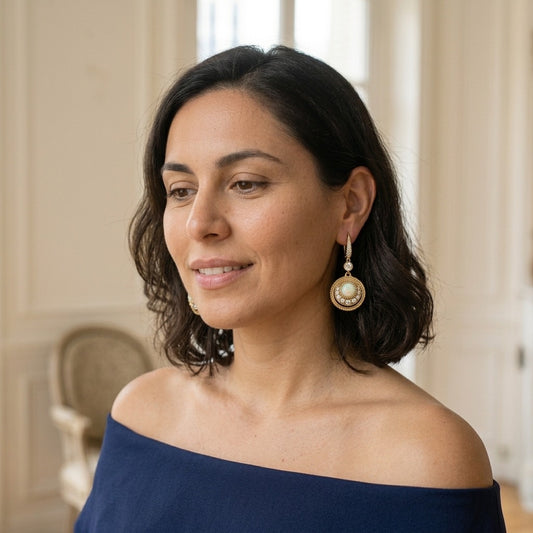 Model wearing the Médaille Drop Earrings, gold-tone brass, simulated opals, simulated diamonds