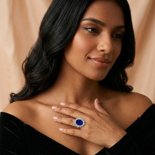 Model wearing the Minuit Ring, an oval lab-grown sapphire with a halo of lab-grown diamonds in 18K white gold